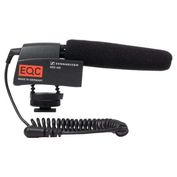 Sennheiser MKE 400 Kameramikrofon schräg von vorne mit Windschutz, Blitzschuhfuß und Klinkenkabel.