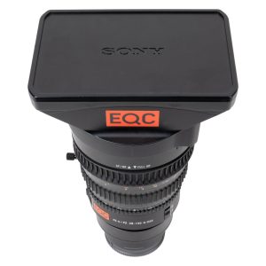 Sony FE PZ 28-135mm f/4 G OSS Motorzoom mit eckiger Streulichtblende und Deckel, stehend von vorne.