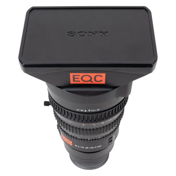 Sony FE PZ 28-135mm f/4 G OSS Motorzoom mit eckiger Streulichtblende und Deckel, stehend von vorne.